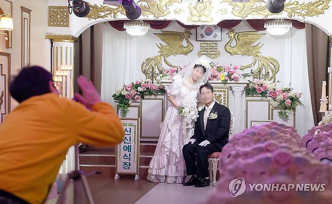 마산 신신예식장 레트로 결혼사진 (창원=연합뉴스) 김동민 기자 = 신신예식장 백남문 대표가 지난 11일 경남 창원시 마산합포구 신신예식장에서 예비 신혼부부의 결혼사진을 촬영하고 있다.     
    이곳은 고 백낙삼 전 대표가 1967년부터 55년간 예식장을 무료로 운영하며 1만4천여 쌍의 부부를 맺어준 뜻깊은 장소로 최근에는 '레트로 결혼사진' 명소로 인기를 끈다. 2026.3.14 image@yna.co.kr