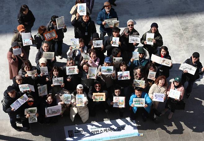 어반스케처 40여 명이 2026년 3월7일 경기도 고양시 덕양구 화정역 문화거리에서 자신들이 그린 ‘도시 풍경화’를 들어 보이고 있다.