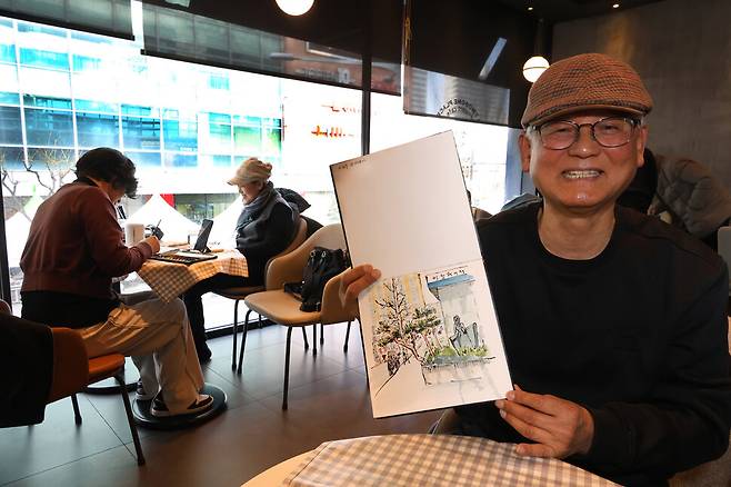 김순구씨가 카페에서 창밖 풍경을 그린 어반스케치를 들어 보이고 있다.