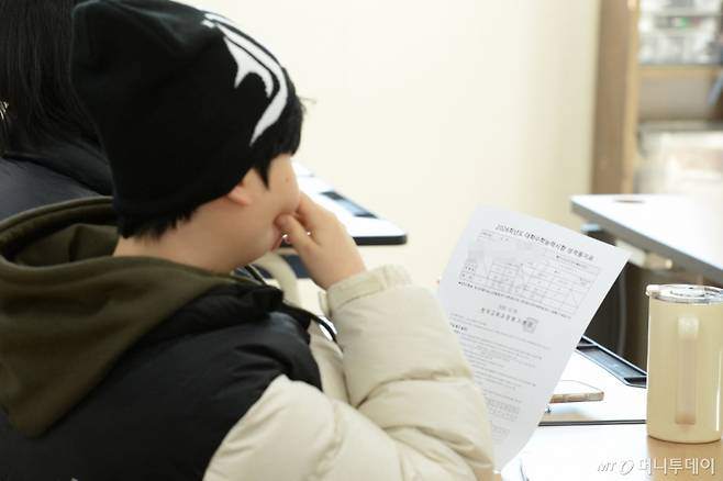 [울산=뉴시스] 배병수 기자 = 2026학년도 대학수학능력시험 성적표가 배부된 5일 울산 중구 다운고등학교에서 수험생들이 수능 성적표를 확인하고 있다.2025.12.05.bbs@newsis.com /사진=배병수