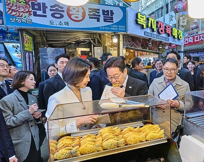 이재명 대통령과 김혜경 여사가 15일 경남 창원시 성산구 반송시장을 찾아 붕어빵을 맛보고 있다. [연합]