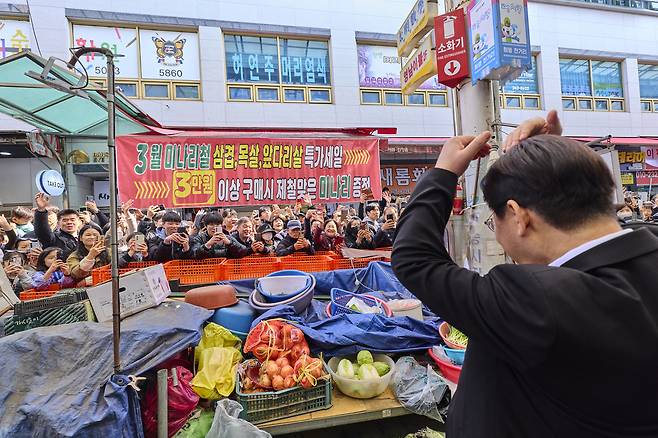 李在明大統領が１５日、慶尚南道昌原市城山区の盤松市場で国民にハートを作っている。写真提供：青瓦台