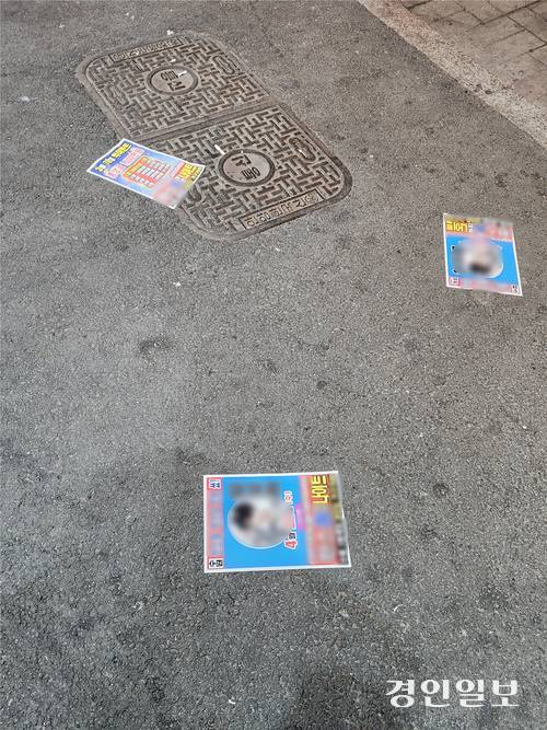 지난 14일 밤 수원시 팔달구 인계동 수원시청 뒤 ‘인계박스’ 길거리에 광고물이 뿌려져 있다. 2026.3.14 /김형욱기자 uk@kyeongin.com