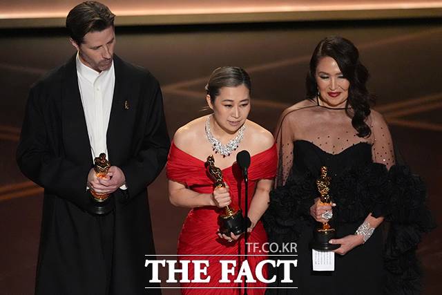 매기 강(가운데) 감독이 15일(현지 시간) 미 캘리포니아주 로스앤젤레스 돌비 극장에서 열린 제98회 아카데미 시상식에서 케이팝 데몬 헌터스(케데헌)로 장편 애니메이션상을 받은 후 소감을 말하고 있다. 왼쪽은 크리스 아펠한스 공동 연출자, 오른쪽은 L.M.웡 프로듀서 /로스앤젤레스=AP.뉴시스