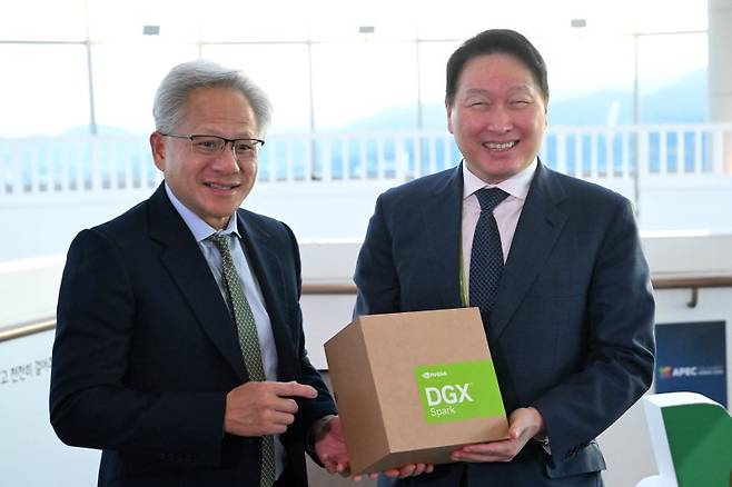 젠슨 황 엔비디아 최고경영자(사진 왼쪽)가 지난해 경북 경주시 경주예술의전당에서 열린 아시아태평양경제협력체(APEC) CEO 서밋에 참석해 최태원 대한상의 회장과 만나 AI슈퍼컴퓨터 'DGX스파크'를 선물하고 있다. 공동취재단
