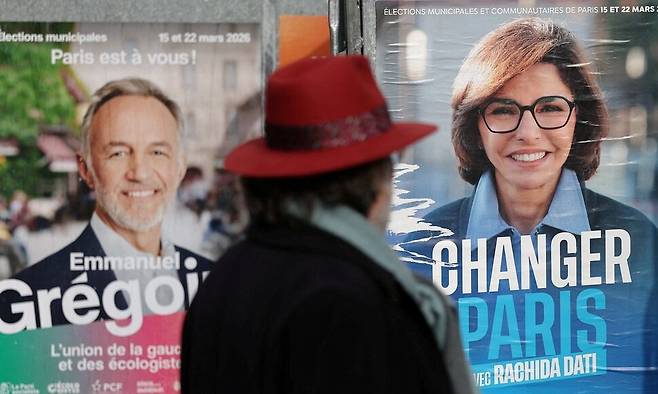 6일 프랑스 파리에서 한 시민이 지방선거 벽보를 보고 있다. 왼쪽 벽보가 사회당 소속 에마뉘엘 그레구아르 후보, 오른쪽이 우파 연합 라시다 다티 후보다. 로이터 연합뉴스