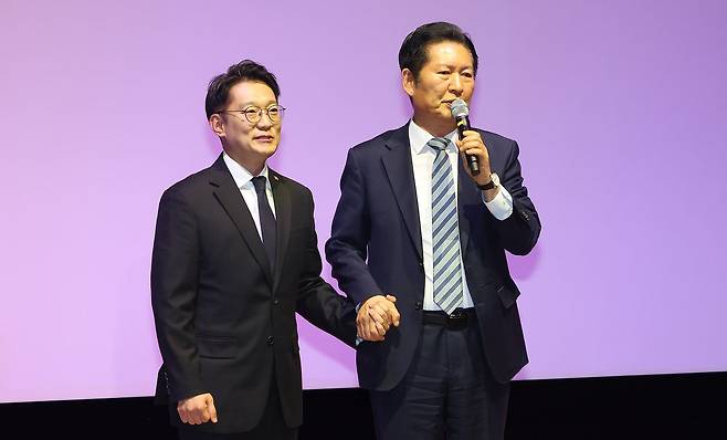 정청래 더불어민주당 대표가 2일 인천 계양구 경인교육대학교에서 열린 김남준 전 청와대 대변인 '쉬운 정치, 김남준' 북콘서트에서 김 전 대변인의 손을 잡고 축사하고 있다. 연합뉴스