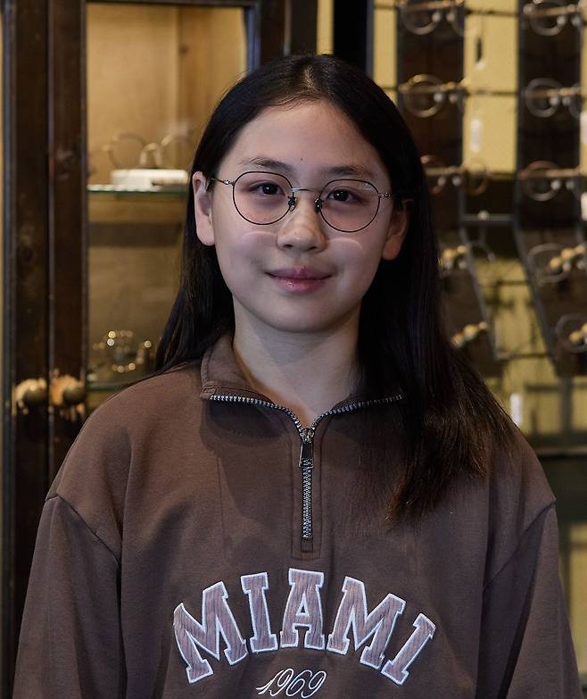 안경을 쓰다가 지난해부터 드림렌즈를 끼고 있는 이윤슬 학생기자는 밑으로 쳐진 원형에 위에 왕관처럼 각이 있는 크라운 판토 스타일 안경을 추천받았다. 검정·회색이 깔끔하게 보이는 얼굴이라 이 테를 쓰면 살짝 톤이 정리되며 피부도 깨끗해 보인다.