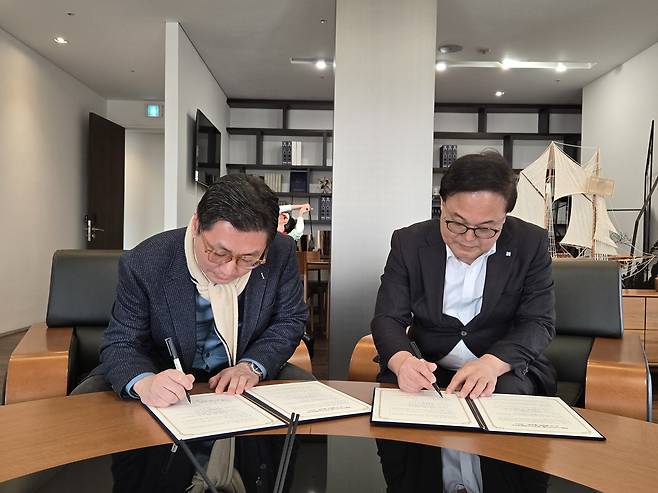 이동현(왼쪽) 한국AI마케팅연구소 대표와 김영상 코리아헤럴드 사장이 AI 기반 K-콘텐츠 활성화 MOU 체결을 위해 사인하고 있다.