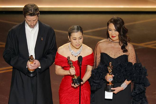한국계 캐나다인 메기 강 감독이 15일(현지시간) 미국 로스앤젤레스(LA)에서 열린 아카데미(오스카) 시상식에서 영화 ‘케이팝 데몬 헌터스’로 장편 애니메이션 상을 받은 뒤 수상 소감을 밝히고 있다. [로이터]
