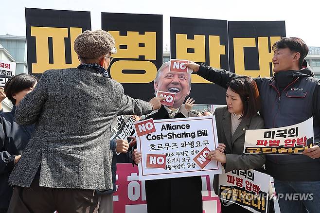 미국의 호르무즈 해협 파병 요구 규탄하며 (서울=연합뉴스) 박동주 기자 = 16일 서울 종로구 주한미국대사관 앞에서 열린 '미국의 호르무즈 해협 파병 요구 규탄 및 파병 반대 긴급 기자회견'에서 참가자들이 '호르무즈 파병 요구' 라고 적힌 팻말에 'NO' 스티커를 붙이고 있다. 2026.3.16 pdj6635@yna.co.kr