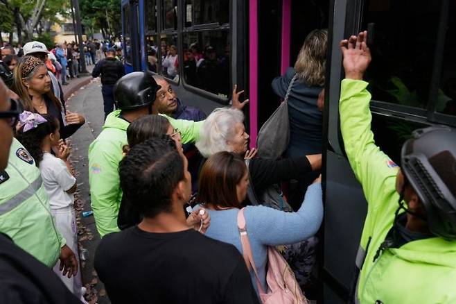 베네수엘라 수도 카라카스에서 운송노조의 파업이 벌어진 가운데, 시민들이 가까스로 버스에 오르고 있다. AP연합뉴스