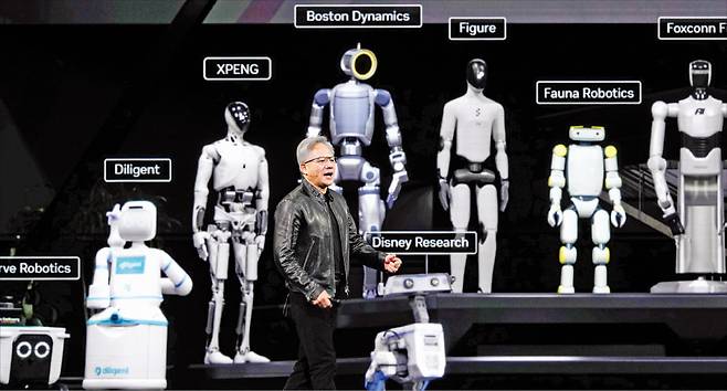 < ‘아틀라스’ 앞에서 연설 젠슨 황 > 엔비디아 최고경영자(CEO)가 16일(현지시간) 미국 새너제이에서 열린 ‘GTC 2026’에서 보스턴다이내믹스의 ‘아틀라스’ 등 휴머노이드 로봇들을 선보이며 피지컬 인공지능(AI)에 대해 발표하고 있다.   AP연합뉴스