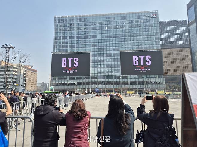 관광객들이 방탄소년단(BTS)의 컴백 공연이 나흘 앞으로 다가온 17일 서울 광화문광장 일대 건물 전광판에 홍보 영상이 나오자 이를 촬영하고 있다. 김태욱 기자