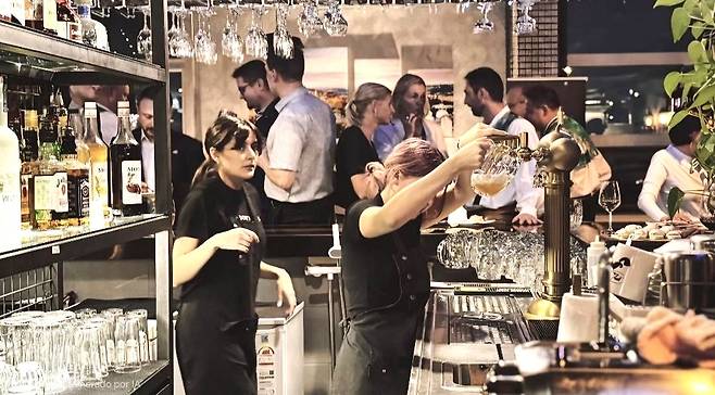 Camila Daniela Paez Rubiano, right, pours beer at a restaurant. [CAMILA DANIELA PAEZ RUBIANO]