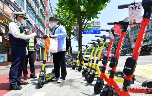 경찰관들이 전동 킥보드 등 개인형 이동장치(Personal Mobility·PM) 이용자들에 대한 계도 활동을 하고 있다. 경기일보DB