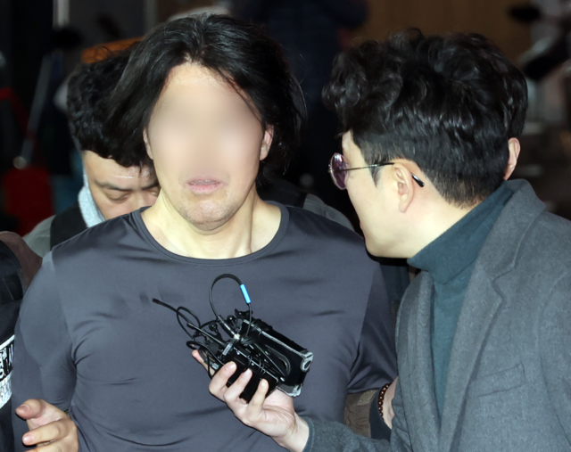 부산에서 전 직장 동료인 항공사 기장을 흉기로 살해한 혐의를 받는 50대 A씨가 17일 부산 부산진경찰서로 압송되고 있다. 뉴시스