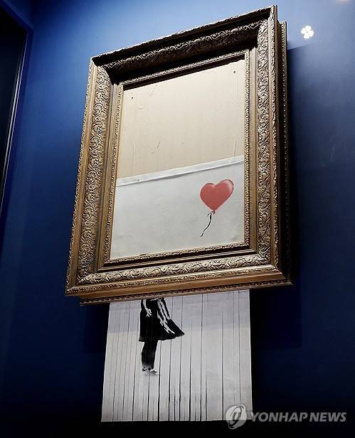 뱅크시 대표작 '풍선을 든 소녀'가 절반쯤 잘려나간 모습 [연합뉴스]