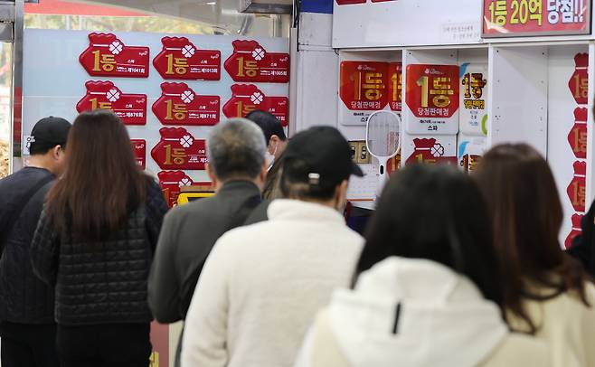 지난해 11월 서울 노원구에 위치한 복권 판매점을 찾은 시민들이 복권을 구매하기 위해 줄을 서 있다. 뉴스1