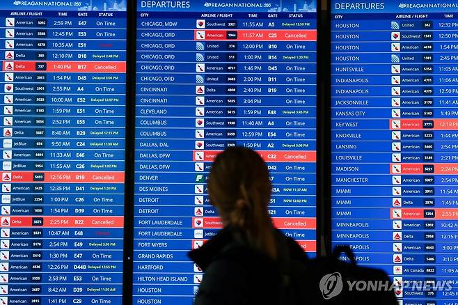 로널드 레이건 공항에서 항공편 취소·지연 현황을 바라보는 승객 [로이터=연합뉴스. 재판매 및 DB 금지]