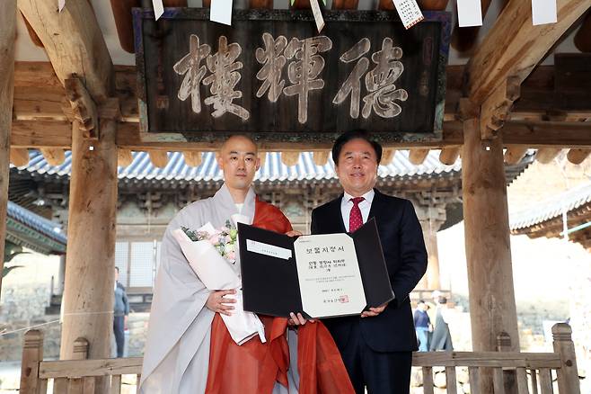 보물로 지정된 봉정사 덕휘루 앞에서 지정서를 전달한 뒤 관계자들이 기념촬영을 하고 있다. /안동시 제공