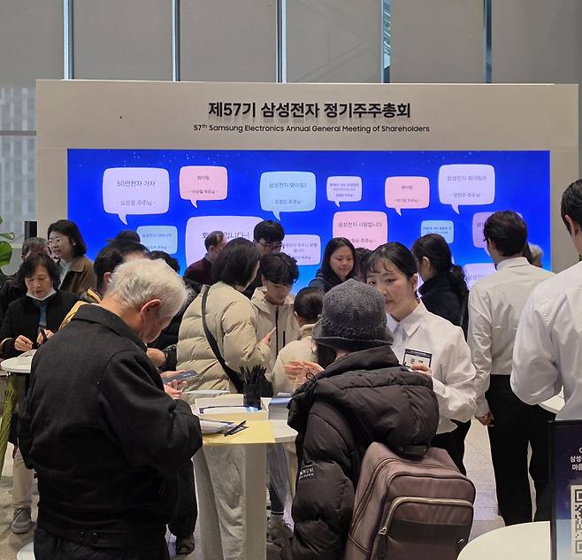 주주들이 주총장에 마련돼 있는 ‘응원 메시지 월(Wall)’에서 메시지를 작성하는 모습.(손희정 기자 sonhj1220@)