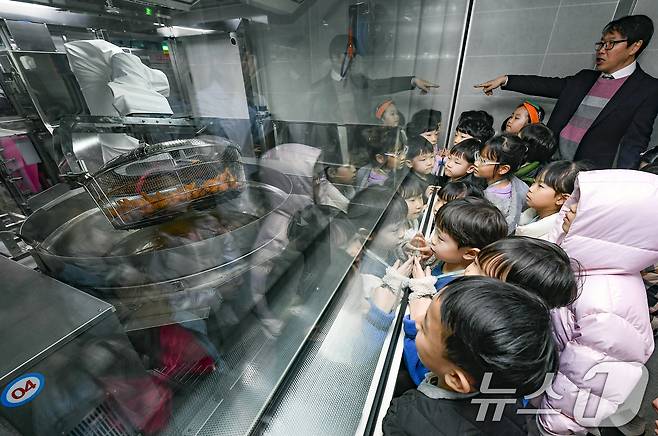 18일 경기 수원시 장안구 대평초등학교 내 위치한 거점형 학교급식 튀김 지원실에서 1학년 학생들이 튀김 조리 로봇이 직접 가동되는 현장을 보고 있다. (공동취재) 2026.3.18 ⓒ 뉴스1 김영운 기자