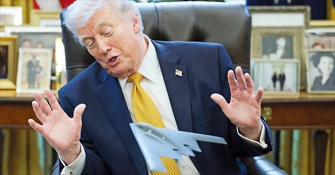 < ‘B-2 폭격기 모형’ 바라보는 트럼프 > 도널드 트럼프 미국 대통령이 16일(현지시간) 백악관 책상에 놓인 B-2 스텔스 폭격기 모형을 바라보며 두 손을 들어 보이고 있다. JD 밴스 부통령이 관할하는 반(反)사기 태스크포스 출범을 위한 행정명령에 서명한 직후다.   로이터연합뉴스