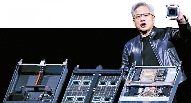 젠슨 황 엔비디아 최고경영자(CEO)가 16일(현지시간) 미국 새너제이에서 열린 엔비디아 연례 개발자회의 ‘GTC 2026’에서 차세대 슈퍼칩을 들어보이고 있다. AFP연합뉴스