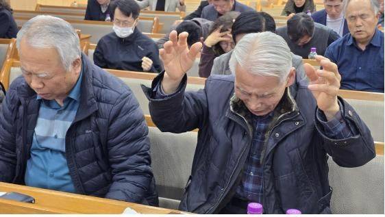 4명의 설교자가 말씀을 전한 후 참석자들이 기도하고 있다.