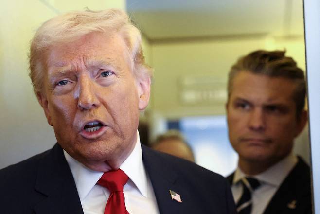 도널드 트럼프 미국 대통령이 지난 7일(현지시간) 미국 델라웨어주 도버에서 플로리다주 마이애미로 향하는 에어포스원 기내에서 기자들과 대화하고 있다. 트럼프 대통령의 발언하는 모습을 뒤쪽에서 피트 헤그세스 국방장관이 지켜보고 있다.[로이터]