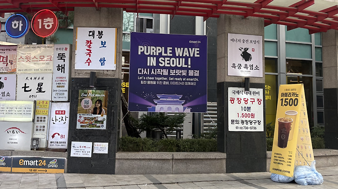 이마트24가  매장 외부에 ‘퍼플 웨이브 인 서울(PURPLE WAVE IN SEOUL)’ 안내 배너를 내걸었다. 박연수 기자