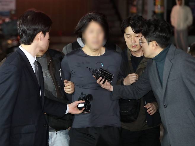 부산의 한 아파트에서 항공사 기장을 흉기로 살해한 혐의를 받는 50대 피의자 김모 씨가 17일 오후 부산진경찰서로 압송되고 있다. 뉴스1