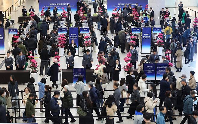 18일 경기도 수원시 영통구 수원컨벤션센터에서 열린 제57기 삼성전자 정기주주총회에서 주주들이 주주 확인을 하고 있다. 연합뉴스