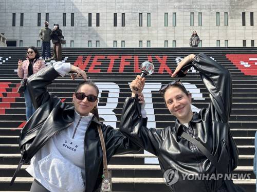 "베네수엘라에서 왔어요" (서울=연합뉴스) 이진주 인턴기자 = 지난 17일 광화문 세종문화회관 앞 'BTS 계단'에서 응원봉을 든 베네수엘라인 아미들이 포즈를 취하고 있다. 2026.3.18