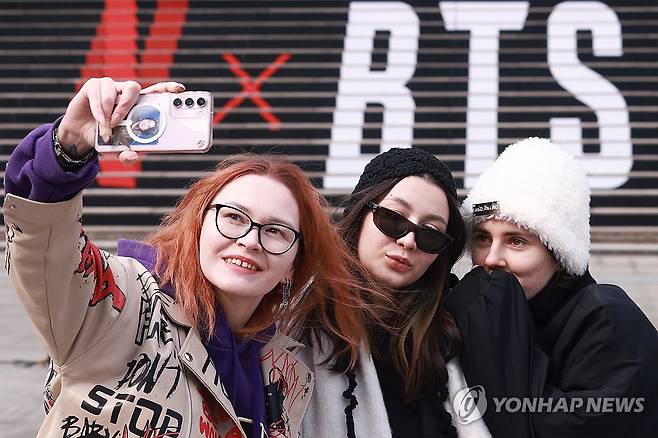 "러시아에서 왔어요" (서울=연합뉴스) 진연수 기자 = 지난 11일 광화문 세종문화회관 계단에서 러시아 관광객들이 '완전체'로 돌아오는 BTS 공연 홍보물을 배경으로 기념촬영을 하고 있다. 2026.3.18 jin90@yna.co.kr