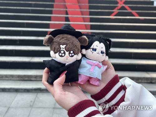 방탄소년단(BTS) 인형 (서울=연합뉴스) 이진주 인턴기자 = 지난 17일 광화문 세종문화회관 'BTS 계단' 앞에서 외국인 유학생이 BTS 인형을 보여주고 있다. 2026.3.18