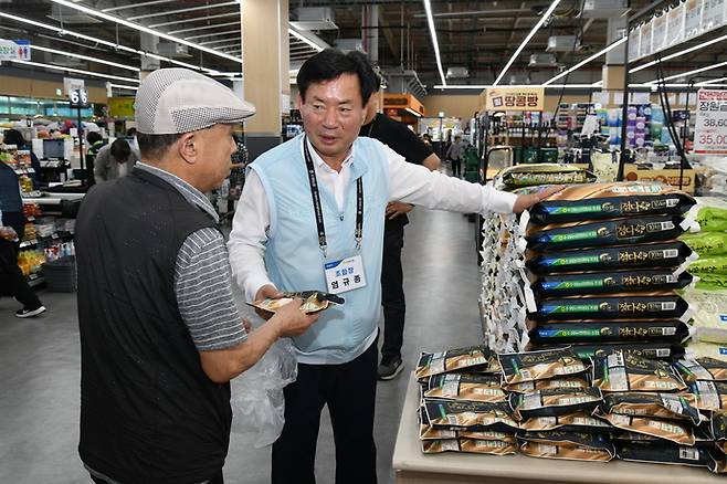 염규종 수원농협 조합장이 지역 내 하나로마트에서 시민에게 정다미를 소개하고 있다. 사진=수원농협