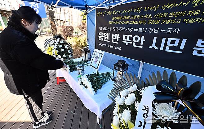19일 오전 수원시 경기지방고용노동청 앞에서 한 시민이 이천 자갈 가공업체에서 일하다 사망한 베트남 국적 23살 이주노동자 응웬 반 뚜안씨의 시민분향소에 헌화를 하고 있다. 김경민기자