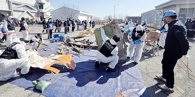 12·29  제주항공 여객기 참사 잔해물 재조사가 열린 19일 무안국제공항에서 경찰 관계자들과 유가족들이 잔해를 살펴보고 있다./서형우 기자