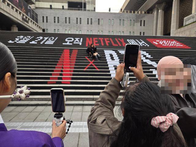 서울 광화문광장을 찾은 팬들이 BTS 새 앨범 홍보 문구로 장식된 세종문화회관 계단에서 기념사진을 촬영하고 있다. [사진=조재형 기자]