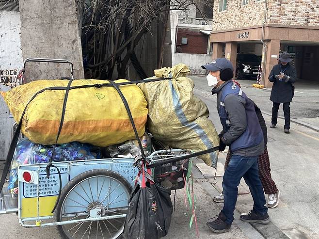 징검다리밥상공동체 대표 장순엽 목사가 지난 11일 서울 강동구 한 고물상 앞에서 어르신의 리어카를 대신 끌고 가고 있다.