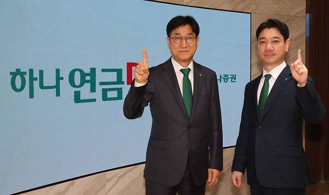 하나은행 퇴직연금그룹을 이끄는 조영순 부행장(왼쪽)과 하나증권 연금사업단 김승균 본부장이 '하나 원'을 뜻하는 포즈를 취하고 있다. 하나금융은 은행, 증권 통합 점포 운영을 통한 맞춤형 고객 상담에 집중하고 있다.  이승환 기자