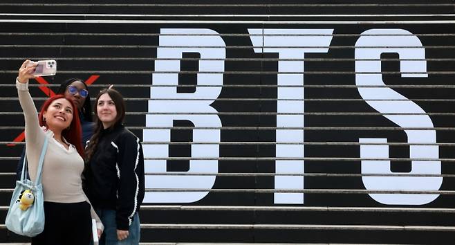 방탄소년단의 컴백 라이브 공연을 열흘 앞둔 11일 서울 종로구 세종문화회관 계단에 마련된 방탄소년단 공연 홍보물 앞에서 외국인 관광객들이 기념촬영을 하고 있다. / 사진 = 뉴스1