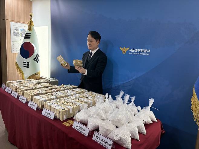 서울 중랑경찰서 관계자가 19일 압수한 범죄수익을 보여주고 있다. 사진제공=서울중랑경찰서