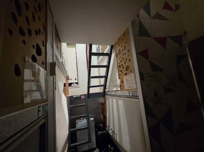 지난 17일 취재진이 투숙한 서울 도심의 한 캡슐호텔의 모습이다. 1층에서 올려다볼 때 3층 침대가 보이지도 않는 상황이다. 사진에서 보이지 않는 문 바로 앞 침대의 경우 3층까지 올라가는 통로가 사다리다.