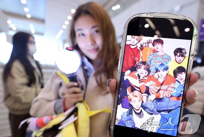 19일 인천국제공항에서 BTS 팬클럽 ‘아미’인 중국인 클로이(20)가 입국하며 아미밤(방탄소년단 공식 응원봉)을 들어 보이고 있다. 오는 21일 서울 광화문광장에서 열리는 BTS 컴백 공연을 관람하기 위해 전 세계 ‘아미’(BTS 팬)들이 속속 한국을 찾고 있다. 2026.3.19 ⓒ 뉴스1 박지혜 기자