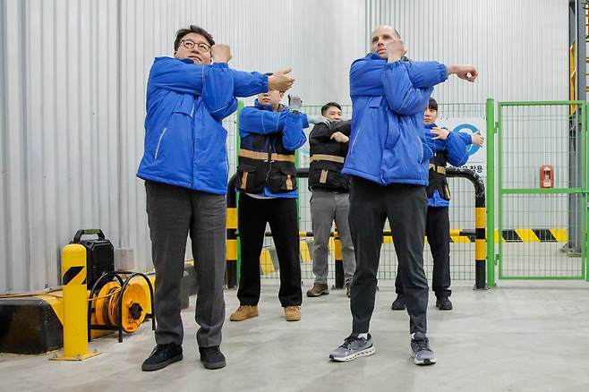 로저스 대표(오른쪽)와 염태영 더불어민주당 의원이 배송체험에 앞서 준비 운동을 하고 있다.(쿠팡 제공).
