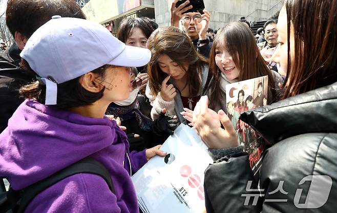 방탄소년단(BTS) 완전체 컴백 공연을 앞둔 20일 서울 광화문광장에서 BTS 팬이 포토카드를 비롯한 굿즈를 나눔하고 있다. 2026.3.20 ⓒ 뉴스1 최지환 기자