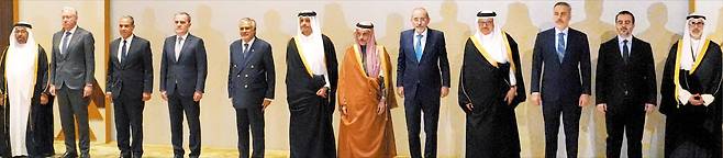 사우디서 아랍·이슬람권 12국 외무장관 회의 19일 사우디아라비아 수도 리야드에서 열린 아랍·이슬람권 12국 외무장관 회의에 앞서 사우디 외무장관인 파이살 빈 파르한 알사우드(주황색 옷) 왕자를 비롯한 참가자들이 기념 촬영을 하고 있다. 회의 도중 리야드에 이란 미사일이 날아들자 이들은 “민간 시설을 표적으로 삼은 행위는 어떤 상황에서도 정당화될 수 없다”고 했다./AP 연합뉴스